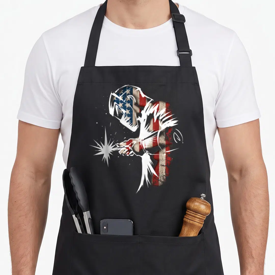 Welder american flag apron - Distressed American flag pattern filling a welding silhouette with white sparkles — shown on a black cotton canvas apron against a white background