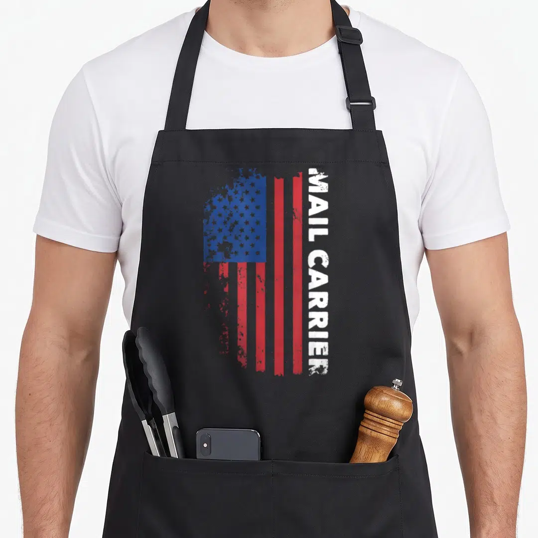 Mail patriotic apron - Vertical distressed USA flag with MAIL CARRIER text along right edge in red white blue — shown on a black cotton canvas apron against a white background