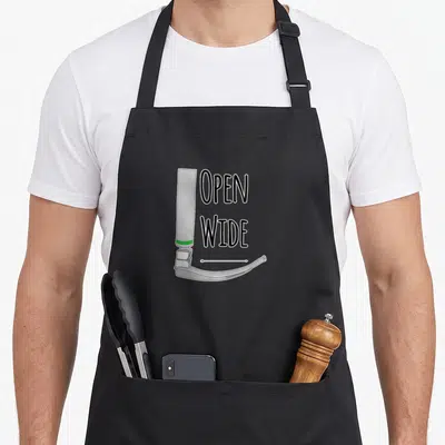 Crna anesthesiologist problems apron - Cartoon laryngoscope with open wide text and white arrow — shown on a black cotton canvas apron against a white background