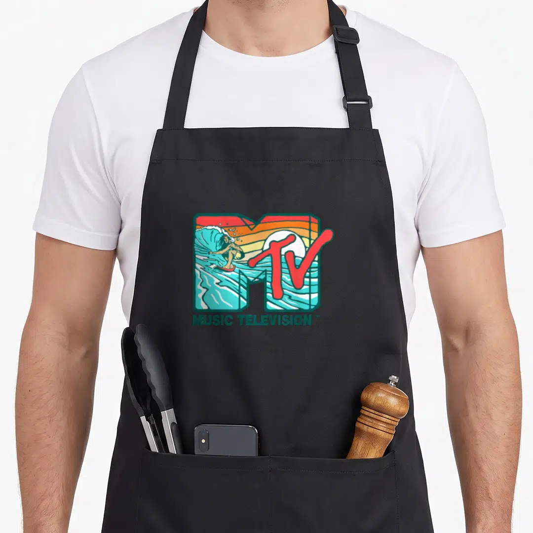 Mtv wave apron - Retro MTV logo with surfer inside M and MUSIC TELEVISION text in teal red orange cartoon style — shown on a black cotton canvas apron against a white background