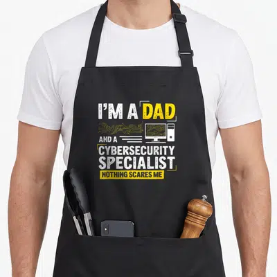 Specialist cybersecurity apron - I'M A DAD AND A CYBERSECURITY SPECIALIST NOTHING SCARES ME text with computer — shown on a black cotton canvas apron against a white background