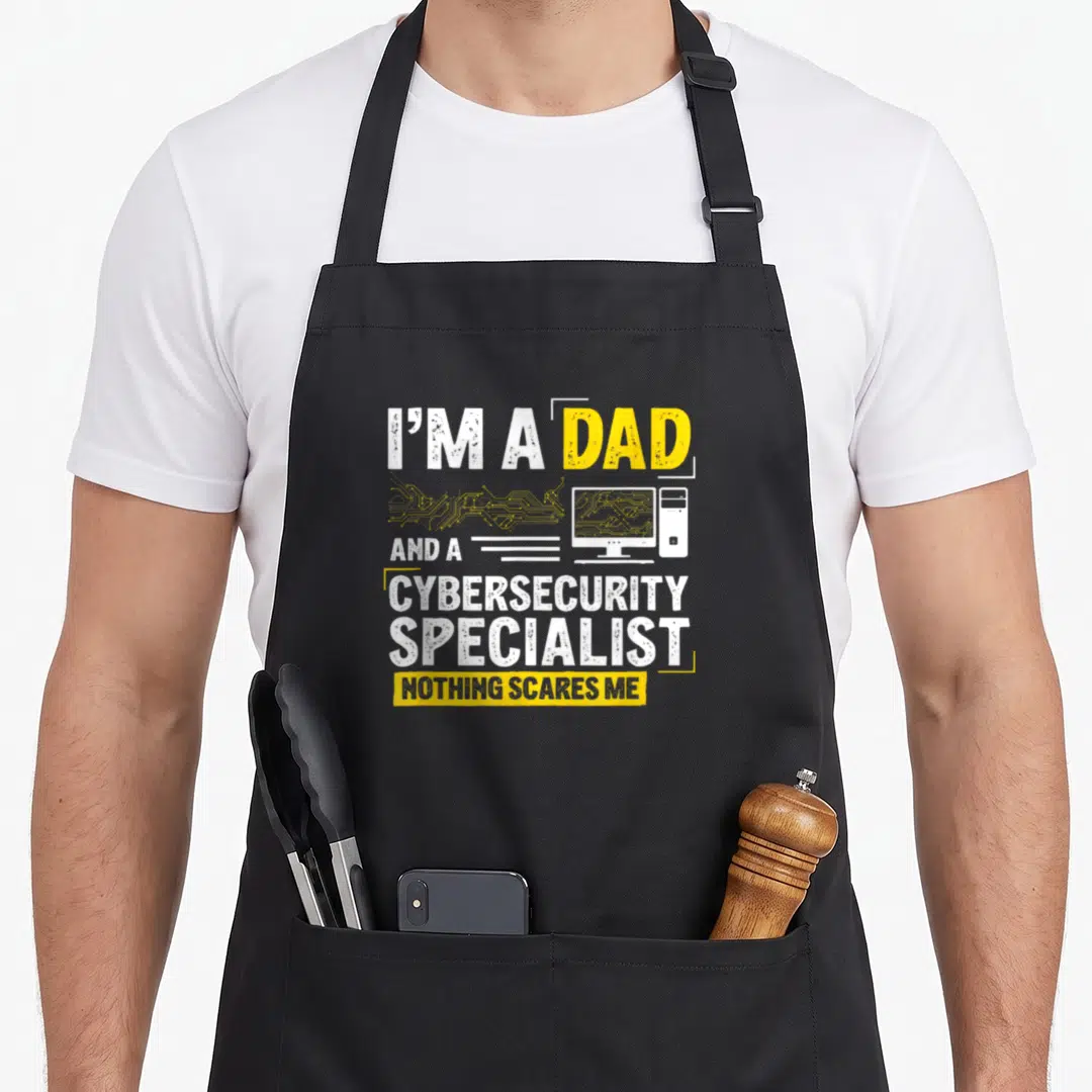 Specialist cybersecurity apron - I'M A DAD AND A CYBERSECURITY SPECIALIST NOTHING SCARES ME text with computer — shown on a black cotton canvas apron against a white background