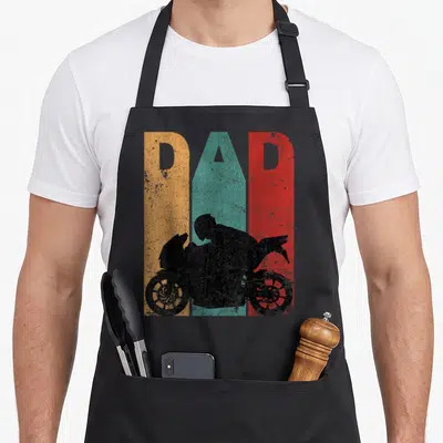 Sport bike apron - DAD cutout over orange teal red stripes with black motorcyclist silhouette — shown on a black cotton canvas apron against a white background