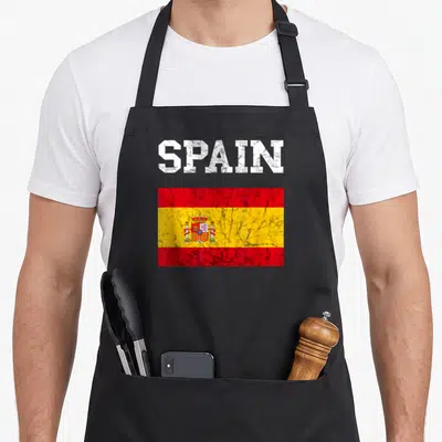Spain spanish aprons - Distressed white SPAIN text above a red yellow and white Spanish flag graphic — shown on a black cotton canvas apron against a white background