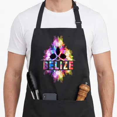 Cultural belizean apron - BELIZE text over symmetrical multicolored tie-dye abstract shape in purple yellow pink blue — shown on a black cotton canvas apron against a white background