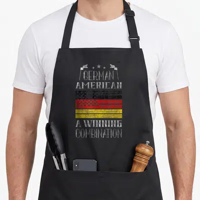 Winning german apron - Combined flag with three stars two small flags and distressed white text — shown on a black cotton canvas apron against a white background