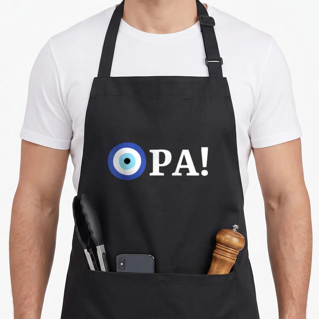 Opa greek aprons - Blue and white evil eye symbol next to bold OPA text — shown on a black cotton canvas apron against a white background