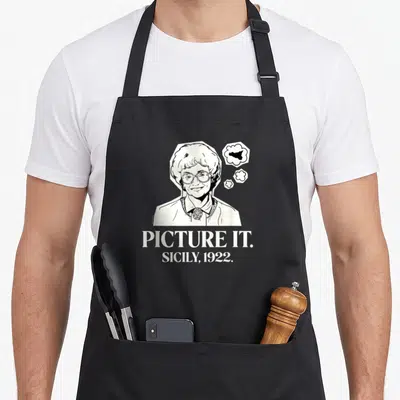 Golden sicily apron - Woman line art with thought bubbles and text Picture It Sicily 1922 — shown on a black cotton canvas apron against a white background