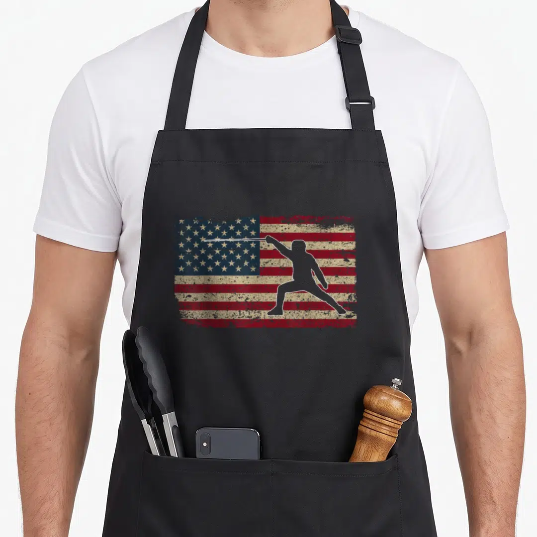 Flag fencing apron - Distressed USA flag with white fencer silhouette extending sword arm — shown on a black cotton canvas apron against a white background