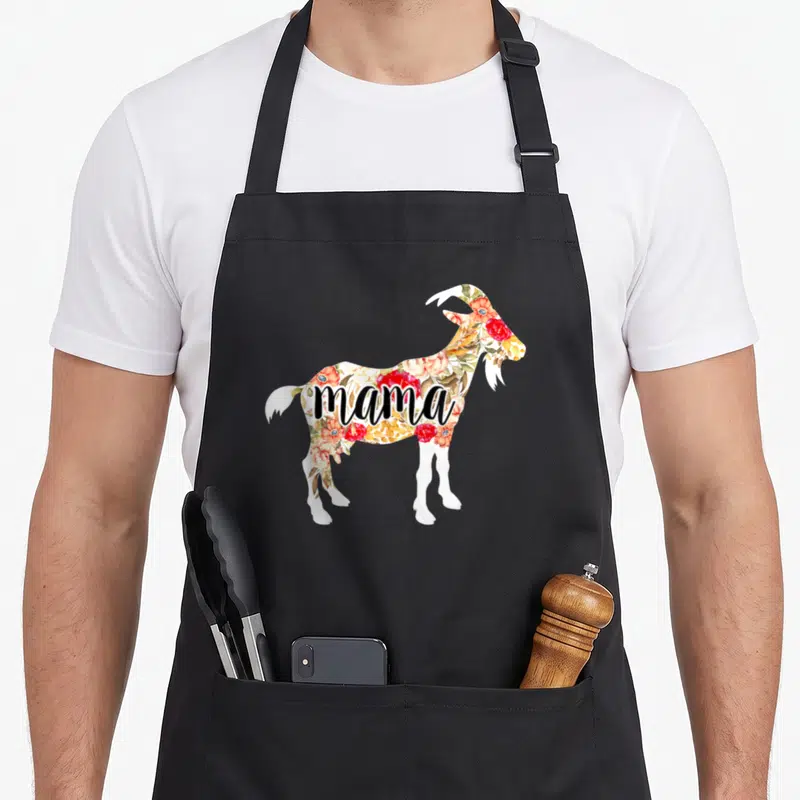 Floral goat aprons - Standing goat filled with red and orange watercolor flowers and black mama text — shown on a black cotton canvas apron against a white background