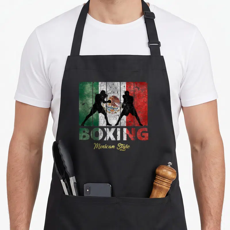 Boxing mexican style apron - Two black boxer silhouettes over distressed green white red flag with BOXING and yellow — shown on a black cotton canvas apron against a white background