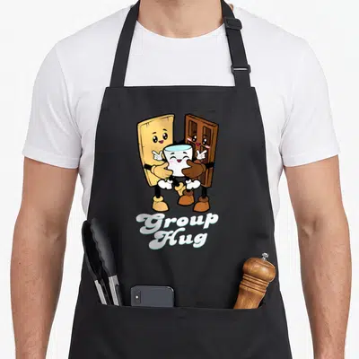 Camping food aprons - Cartoon graham cracker chocolate bar and marshmallow mug hugging with Group Hug script text below — shown on a black cotton canvas apron against a white background