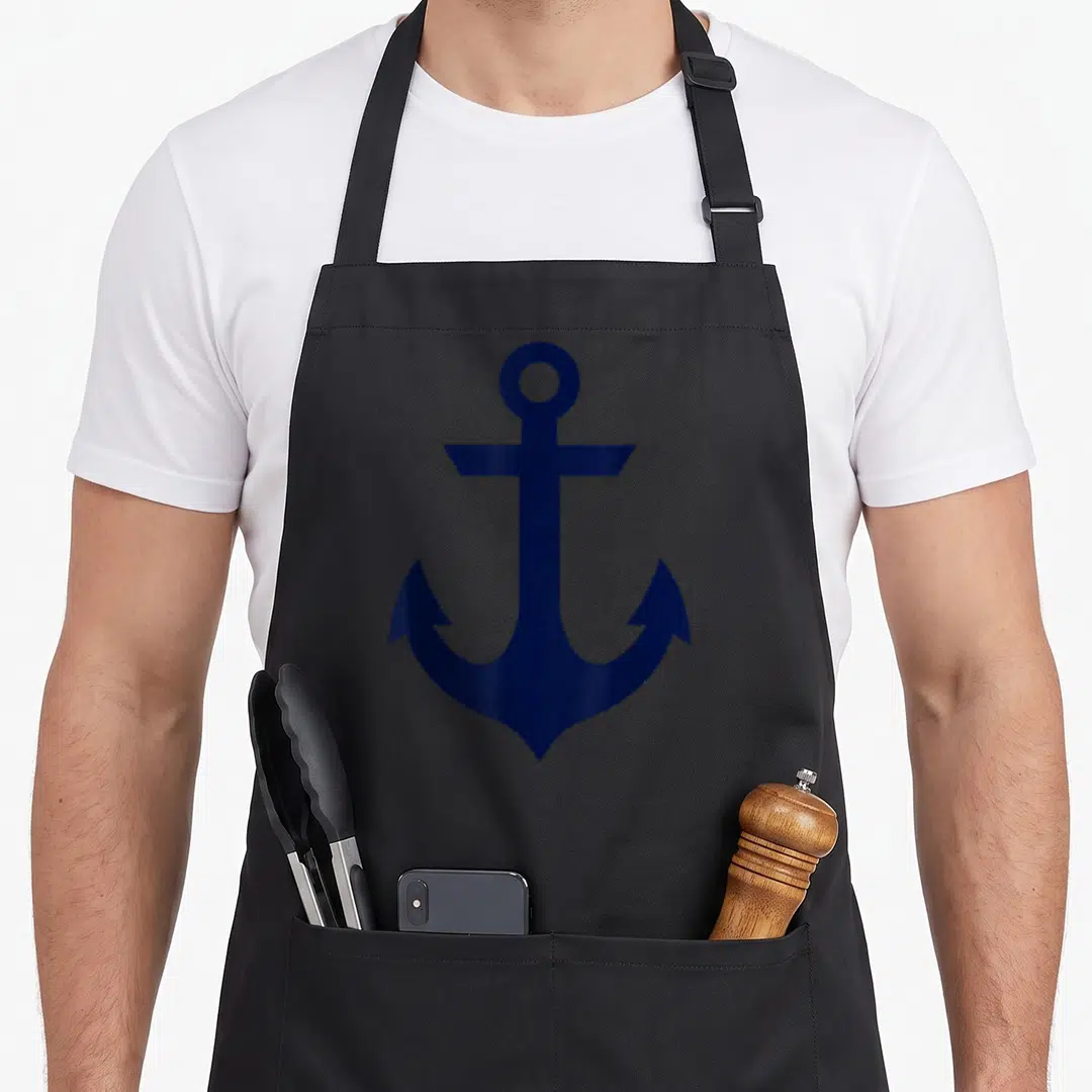 Preppy nautical apron - Minimalist navy blue anchor centered on grey background — shown on a black cotton canvas apron against a white background