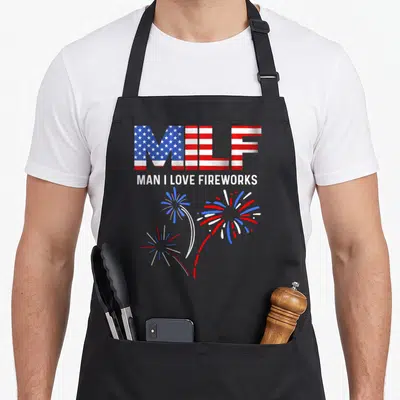 Milf 4th of july apron - MILF flag acronym, Man I Love Fireworks text, three red white blue fireworks — shown on a black cotton canvas apron against a white background