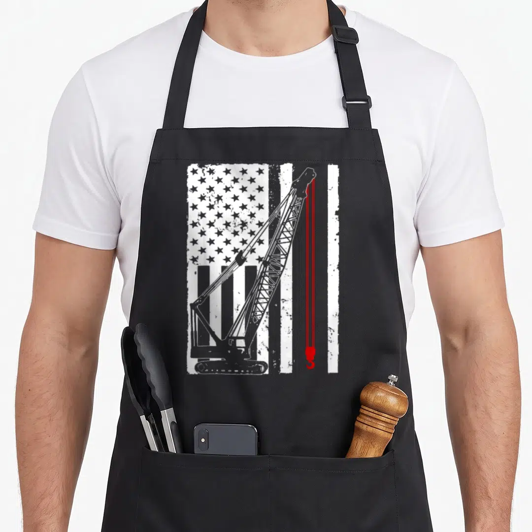 Crane heavy canvas aprons - White crane and red hook on distressed USA flag background — shown on a black cotton canvas apron against a white background