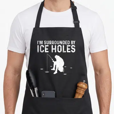 Snow fishing aprons - White fisherman silhouette surrounded by ice holes under stacked text — shown on a black cotton canvas apron against a white background