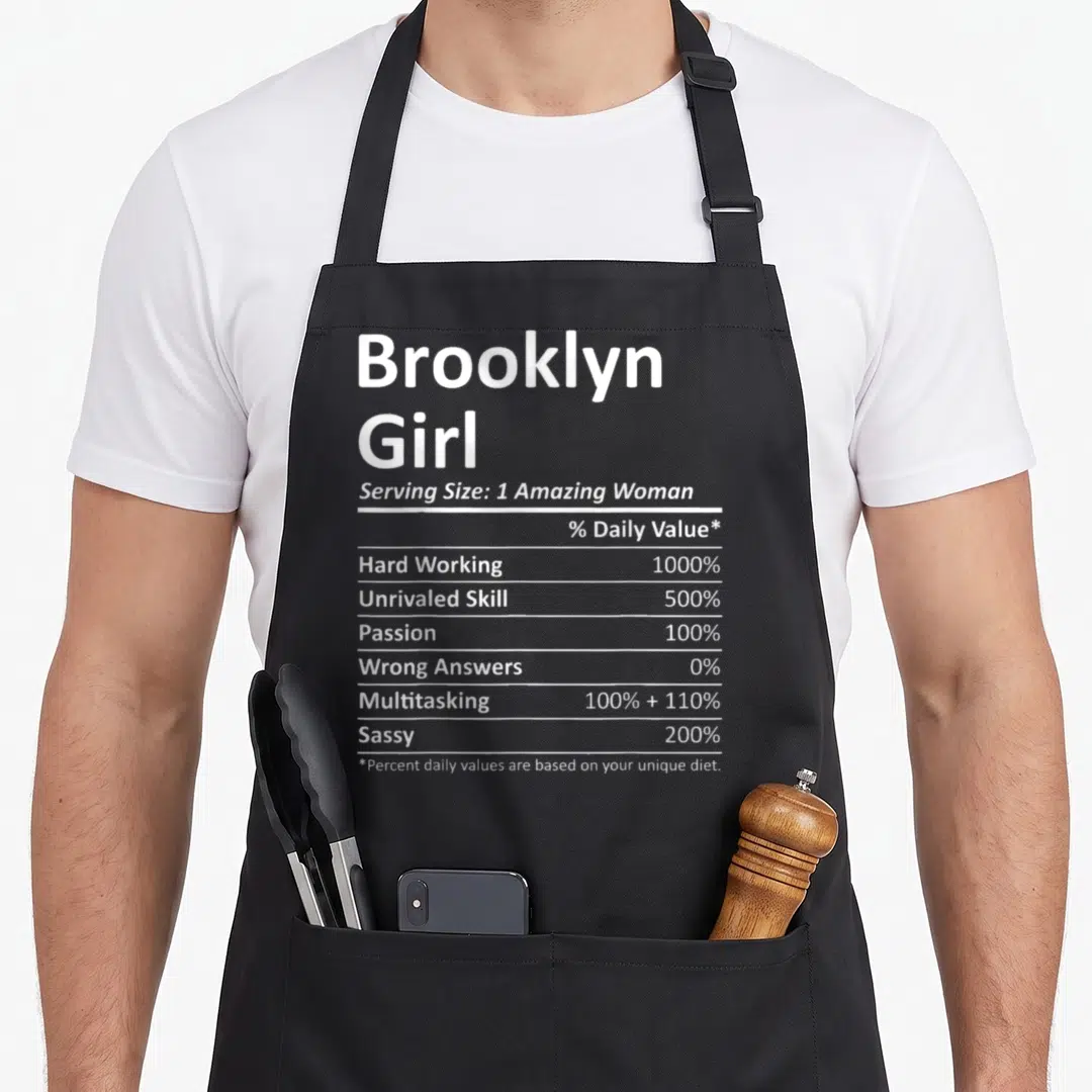 Brooklyn root new york apron - White nutrition facts style text listing Sassy 200% and Multitasking 100% plus 110% — shown on a black cotton canvas apron against a white background