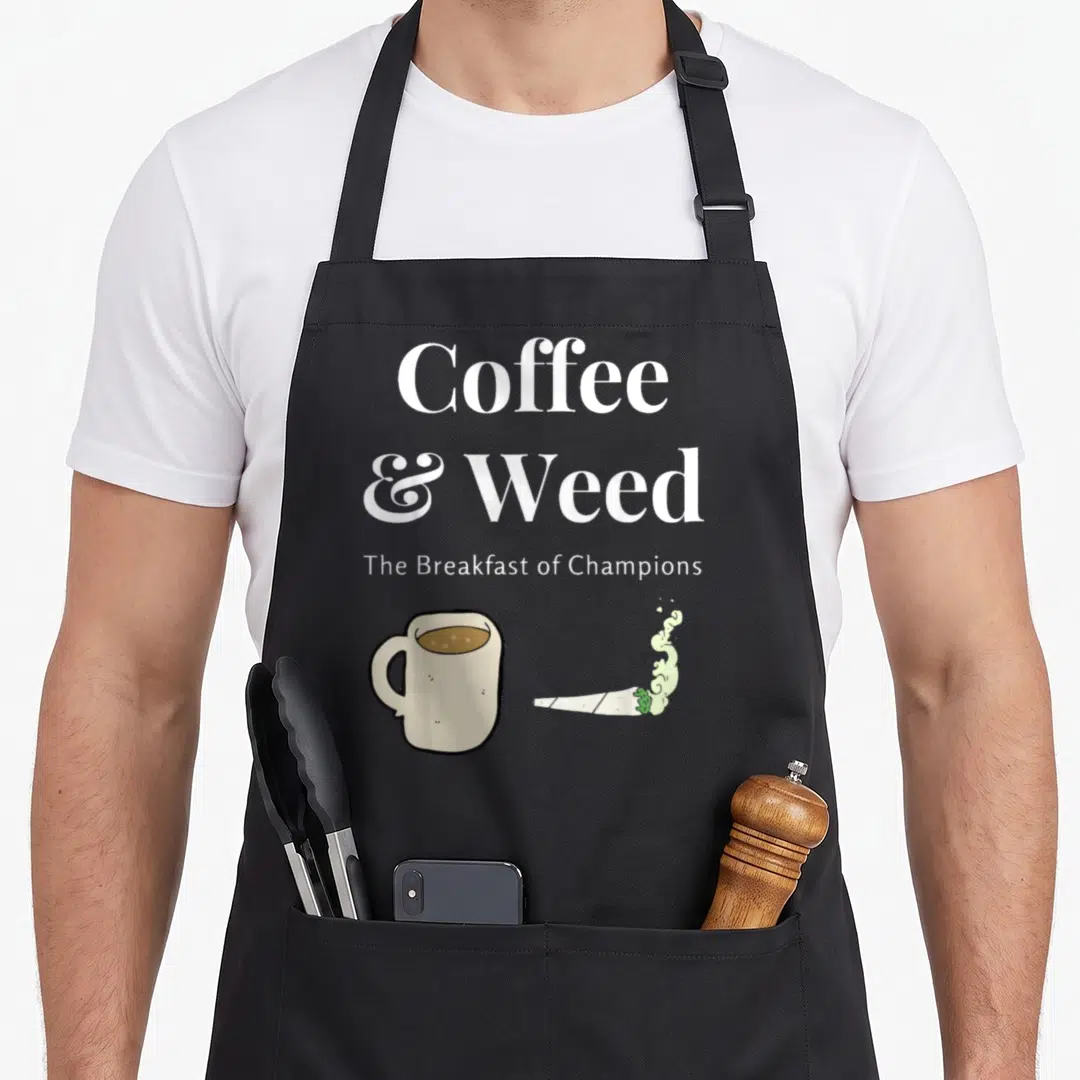 Weed coffee apron - Stacked text Coffee & Weed above a beige mug and smoking joint in cartoon style — shown on a black cotton canvas apron against a white background