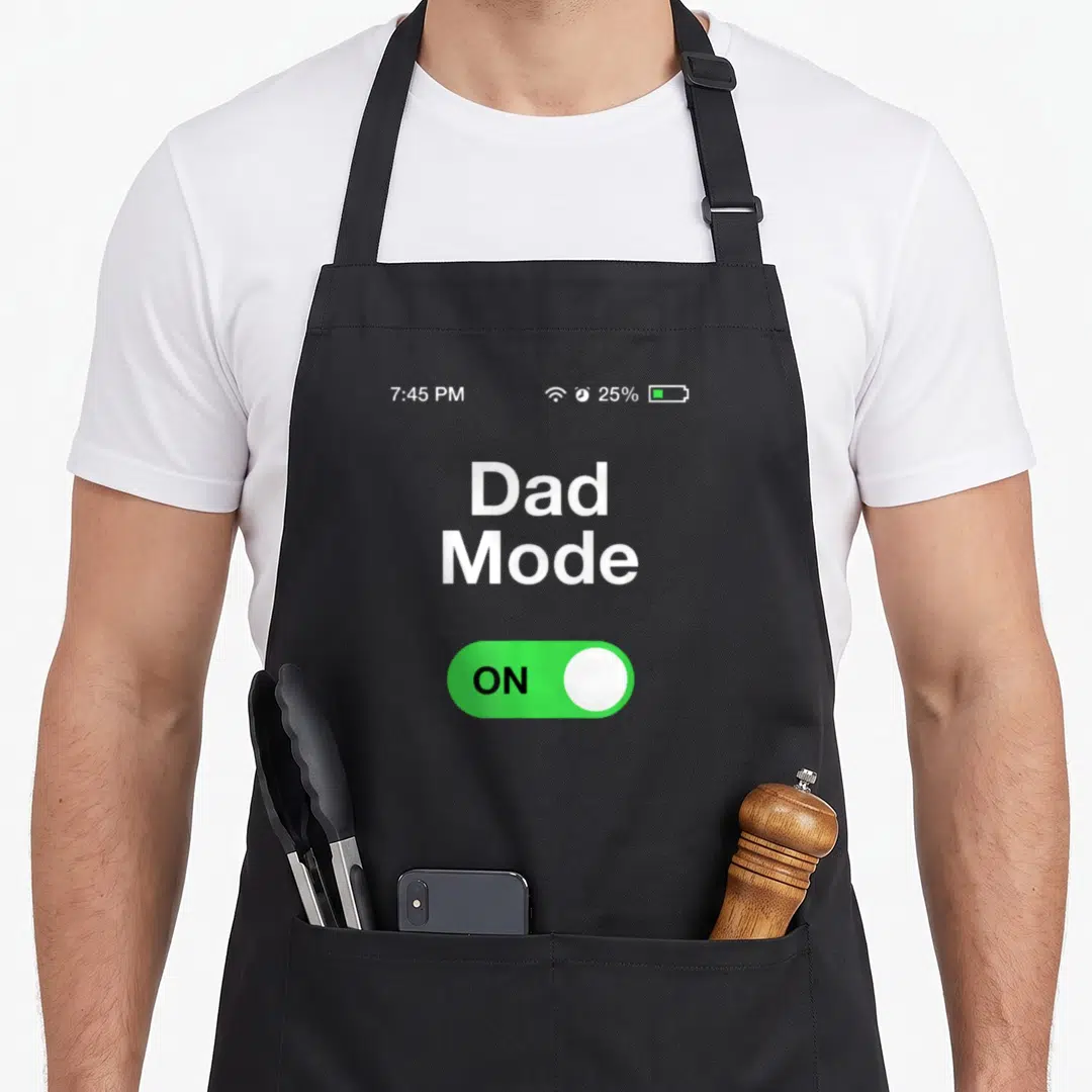 Mode father day apron - Smartphone lock screen print showing Dad Mode ON toggle, 7:45 PM time, and 25% battery icon — shown on a black cotton canvas apron against a white background