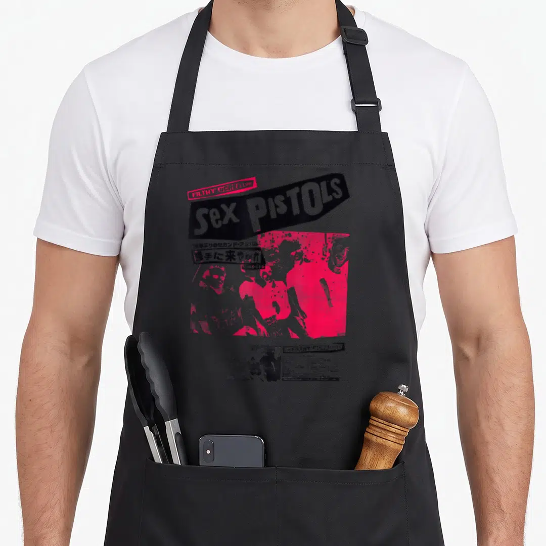 Pistol japan apron - Sex Pistols FILTHY LUCRE Live poster art with Japanese text and pink band photos — shown on a black cotton canvas apron against a white background