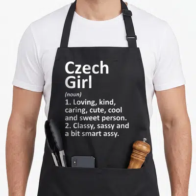 Czech country apron - White Czech Girl noun definition typography listing kind and sassy traits — shown on a black cotton canvas apron against a white background