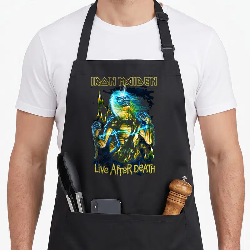 Live camping apron - Electrified zombie surrounded by fire and smoke with Iron Maiden and Live After Death text — shown on a black cotton canvas apron against a white background