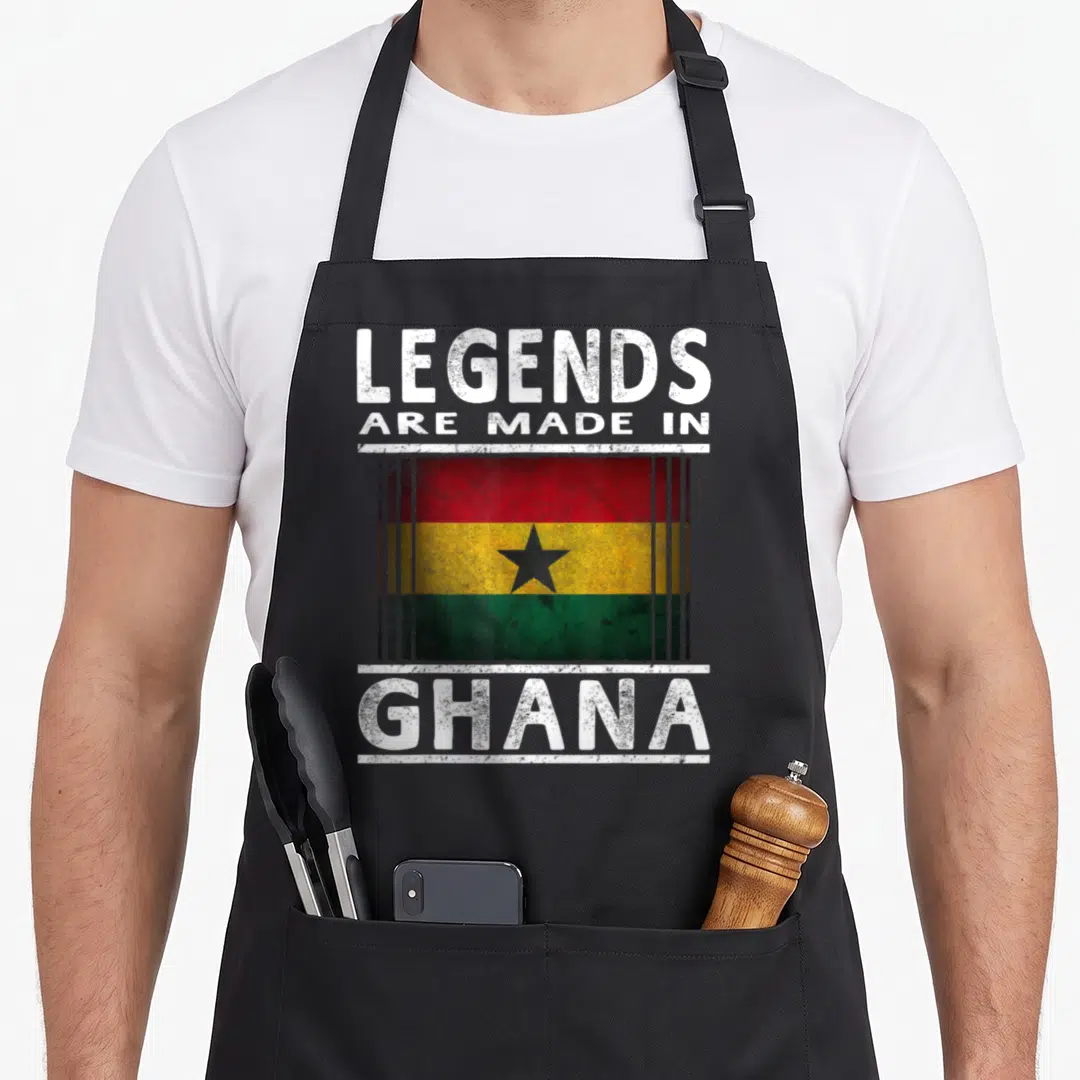 Legend ghanaian boy apron - Distressed text Legends Are Made In Ghana surrounding a Ghana flag with red yellow green — shown on a black cotton canvas apron against a white background