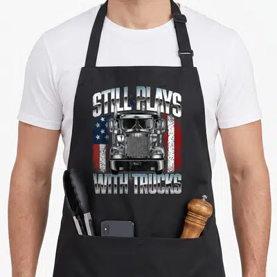 Play driver semi truck apron - Realistic truck front view on distressed American flag with arched text still plays — shown on a black cotton canvas apron against a white background