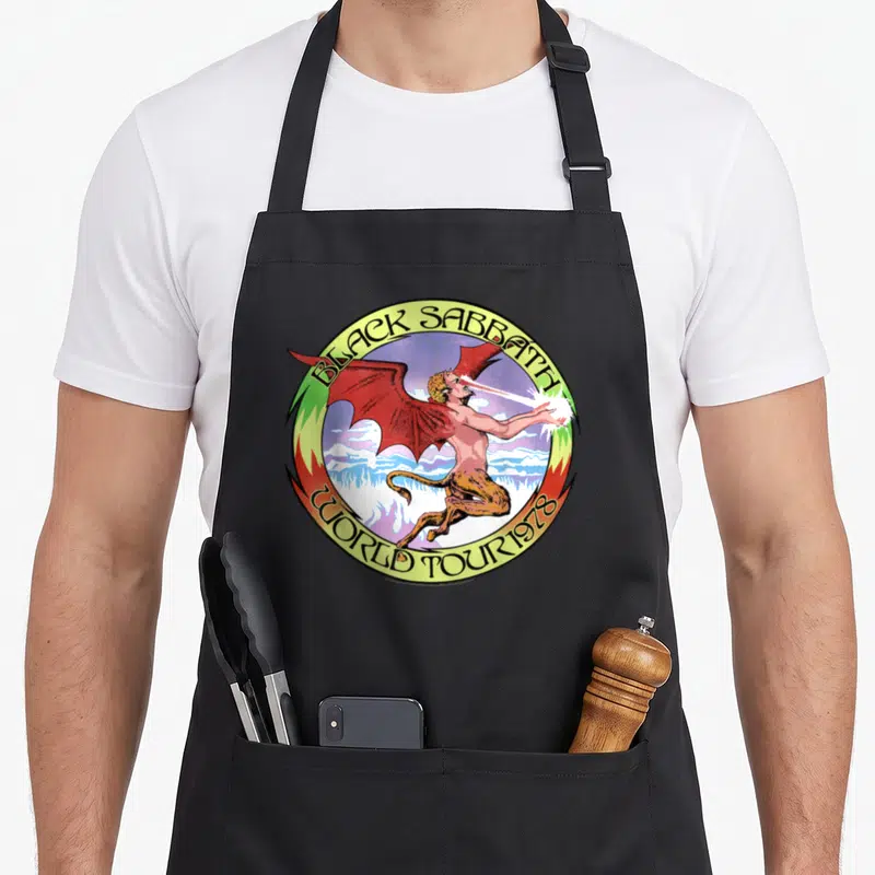 Tour black officially apron - Demon with red wings inside yellow circle reading BLACK SABBATH WORLD TOUR 1978 — shown on a black cotton canvas apron against a white background