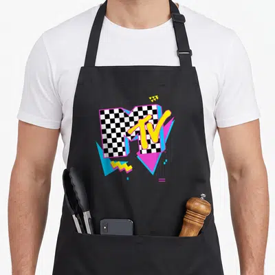 Neon checkered apron - MTV logo with checkerboard M, yellow TV text, pink blue triangles, and yellow zigzag on grey — shown on a black cotton canvas apron against a white background