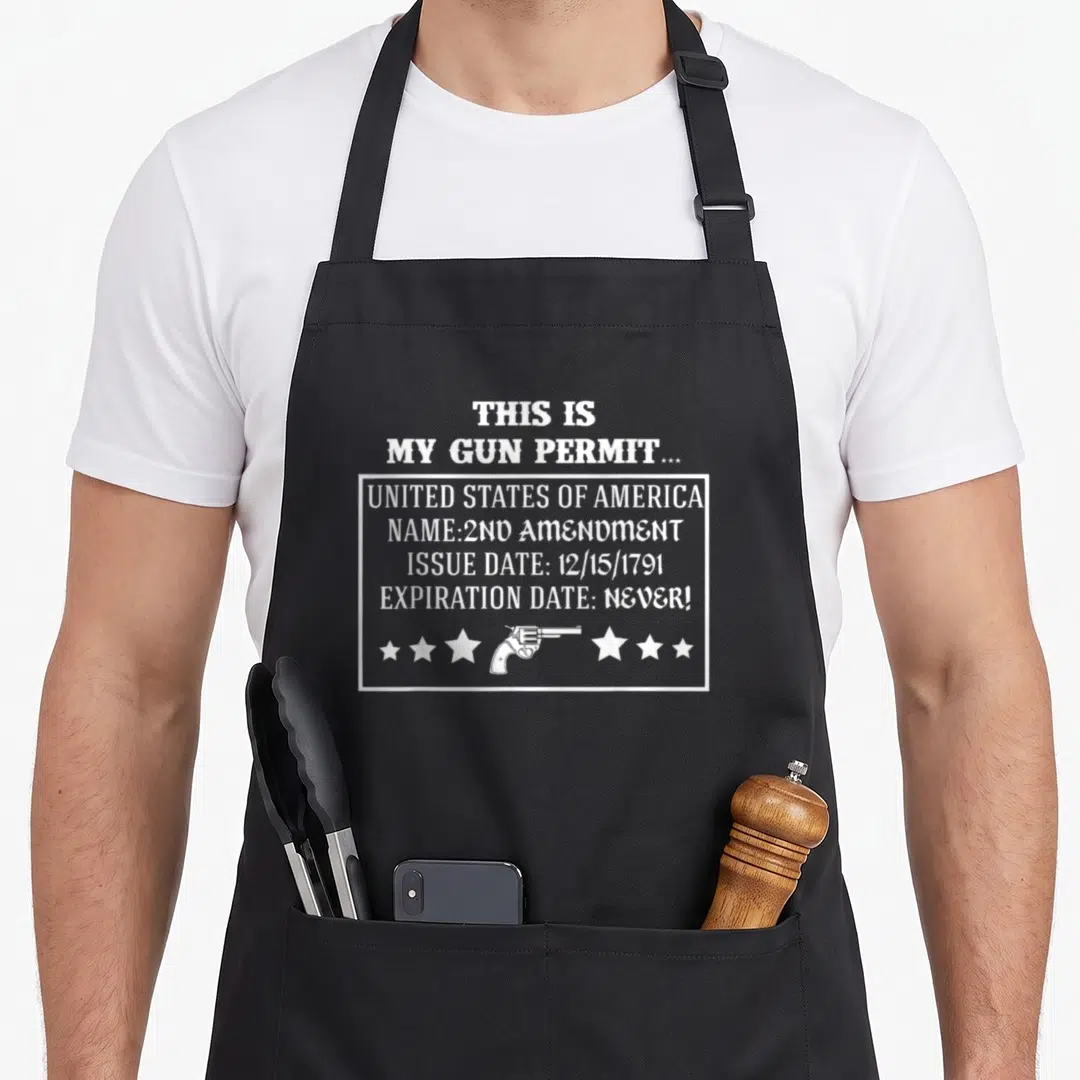 Gun permit 2nd apron - White text reading THIS IS MY GUN PERMIT with revolver and stars below a box — shown on a black cotton canvas apron against a white background