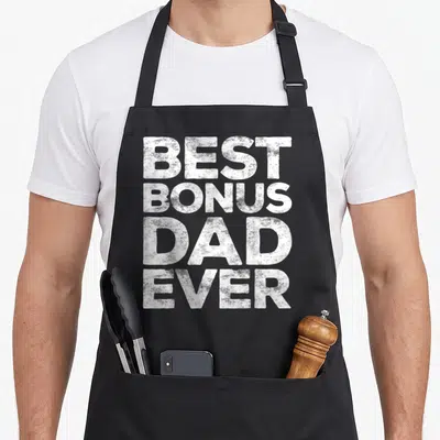 Bonus stepdad father day apron - White stacked text reading BEST BONUS DAD EVER in bold distressed font — shown on a black cotton canvas apron against a white background