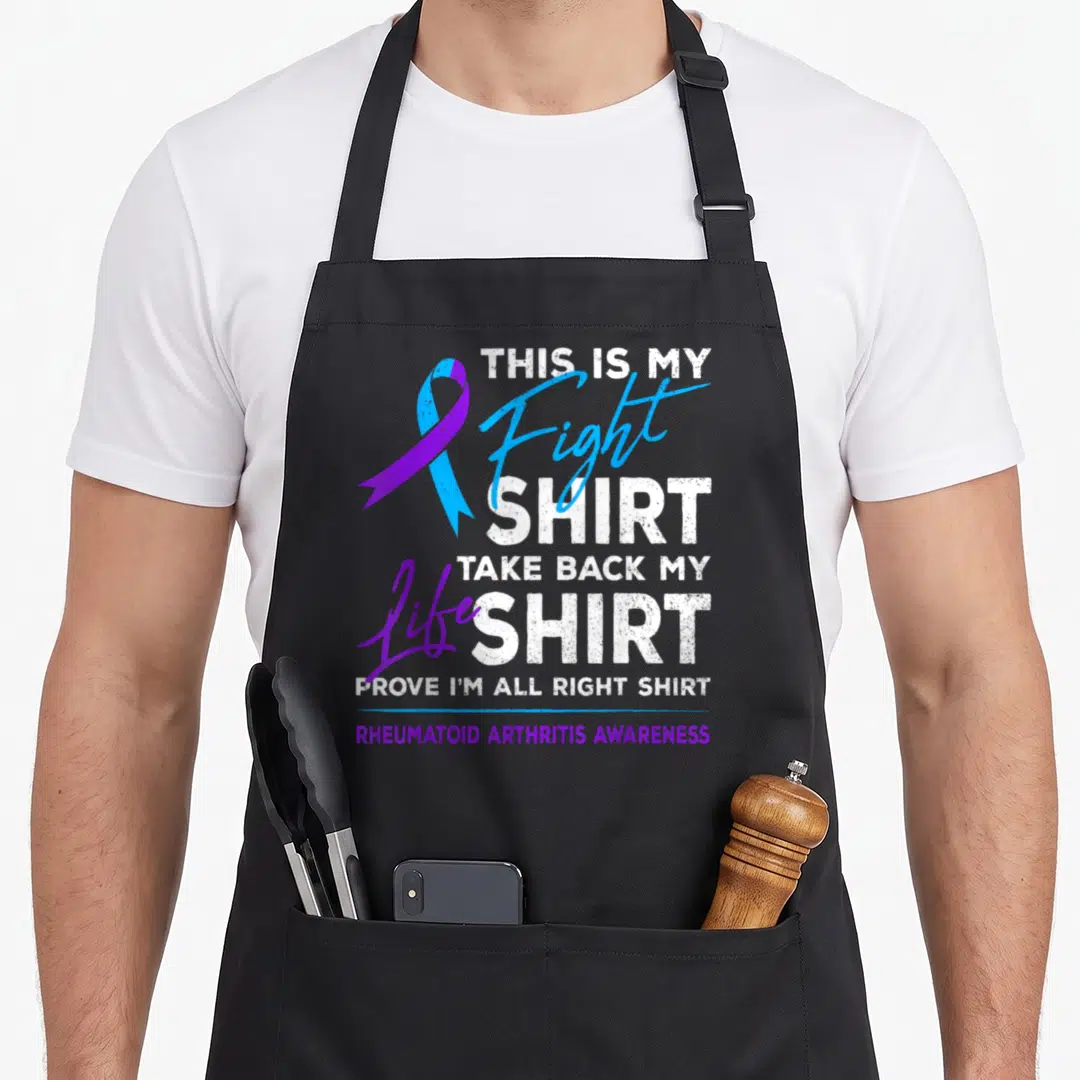 Fight rheumatoid ribbon apron - Blue and purple RA awareness ribbon with distressed white and purple text reading THIS — shown on a black cotton canvas apron against a white background