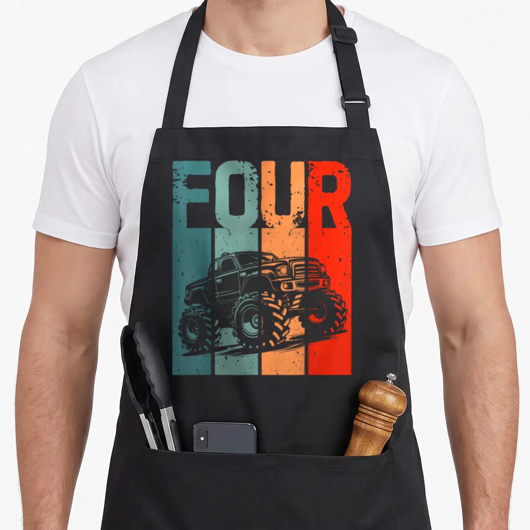 Roll truck apron - Grey monster truck over teal orange red grey stripes with the word FOUR at top — shown on a black cotton canvas apron against a white background