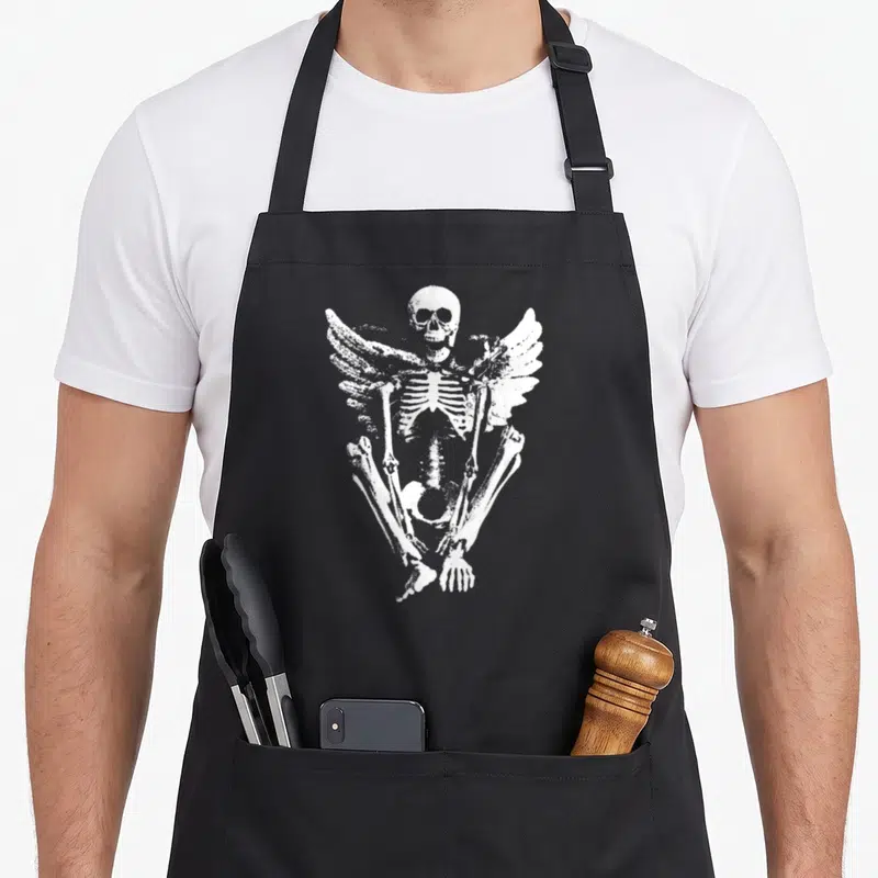Angel goth apron - White distressed winged skeleton graphic on heavy canvas — shown on a black cotton canvas apron against a white background