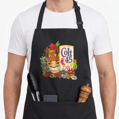 Colt beer apron - Cartoon horse head grinning next to Colt 45 can surrounded by red blue and yellow flowers — shown on a black cotton canvas apron against a white background