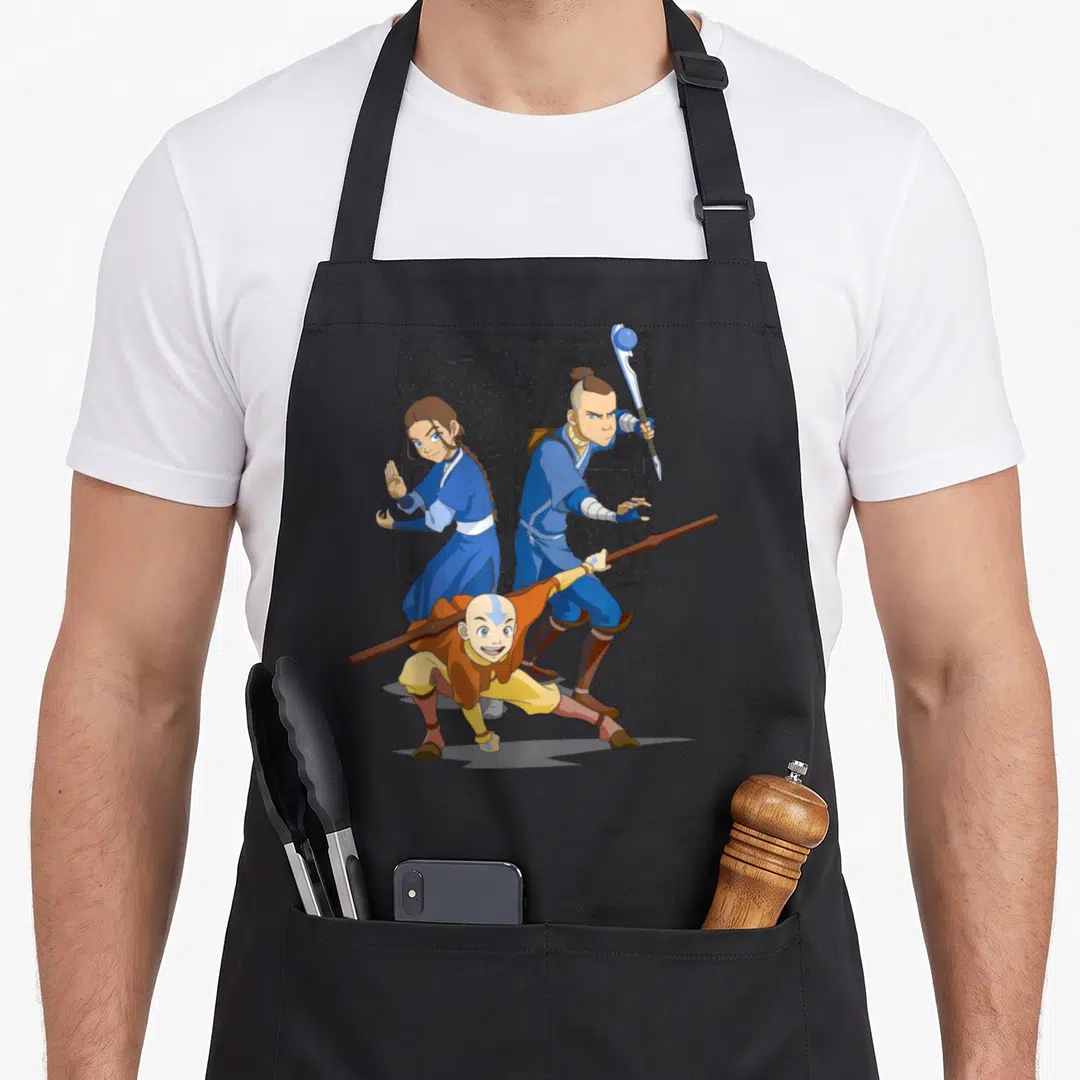 Main group shot apron - Aang crouching with Katara and Sokka against grey symbols in cartoon style — shown on a black cotton canvas apron against a white background