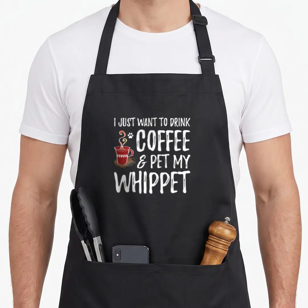 Whippet coffee dog apron - Stacked white text next to red cup, brown stain, and small paw print — shown on a black cotton canvas apron against a white background
