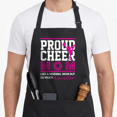Proud cheerleading apron - Pink and white typography design with cheerleader silhouette and slogan about being loud — shown on a black cotton canvas apron against a white background