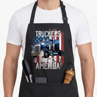 Move semi truck apron - Blue semi-truck on distressed flag with TRUCKERS MOVE AMERICA text — shown on a black cotton canvas apron against a white background