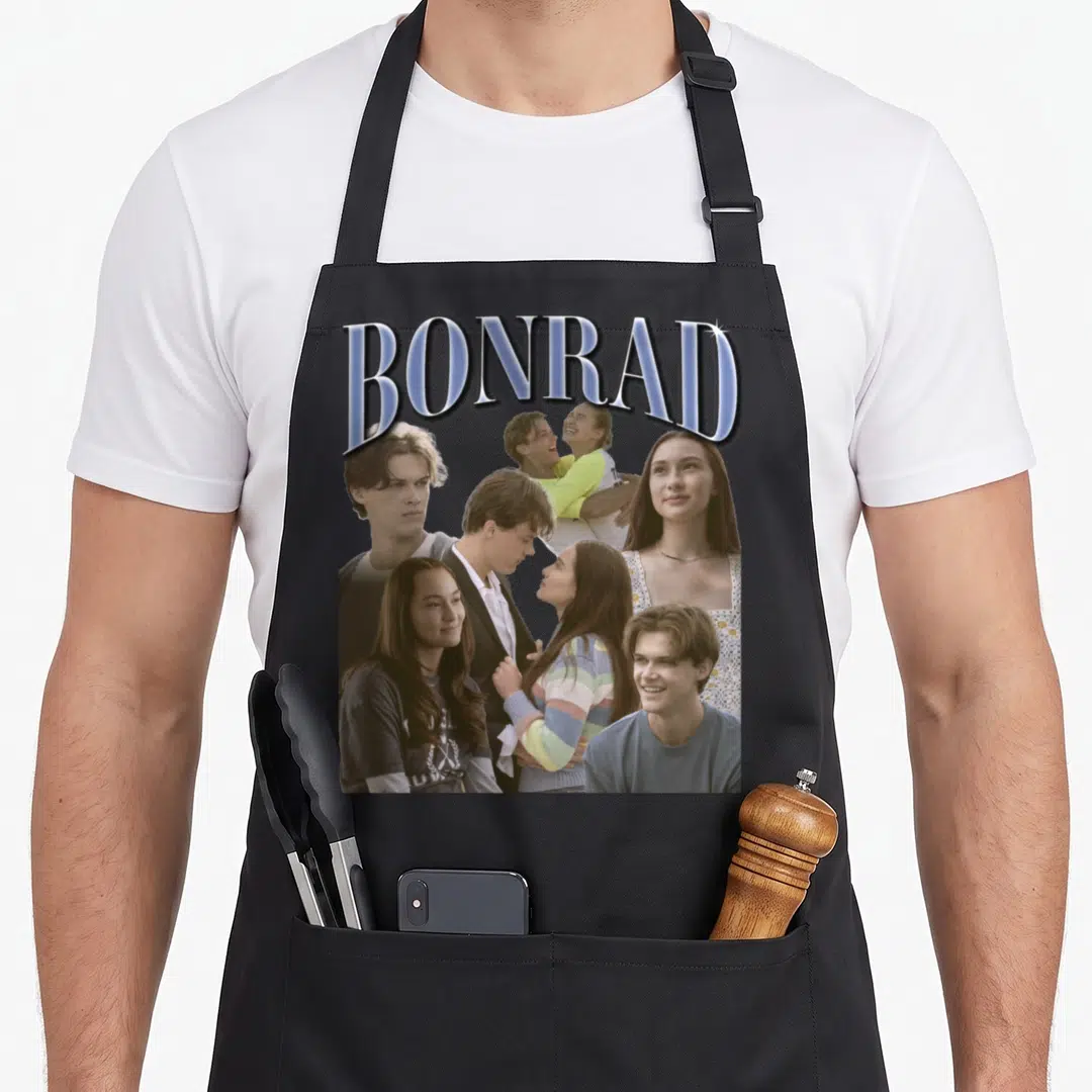 Bonrad pretty apron - Arched BONRAD text above photo collage of a man and woman in blue grey and white tones on a black — shown on a black cotton canvas apron against a white background