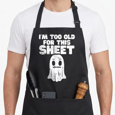 Ghost costume halloween apron - White distressed ghost below stacked text reading I'M TOO OLD FOR THIS SHEET — shown on a black cotton canvas apron against a white background