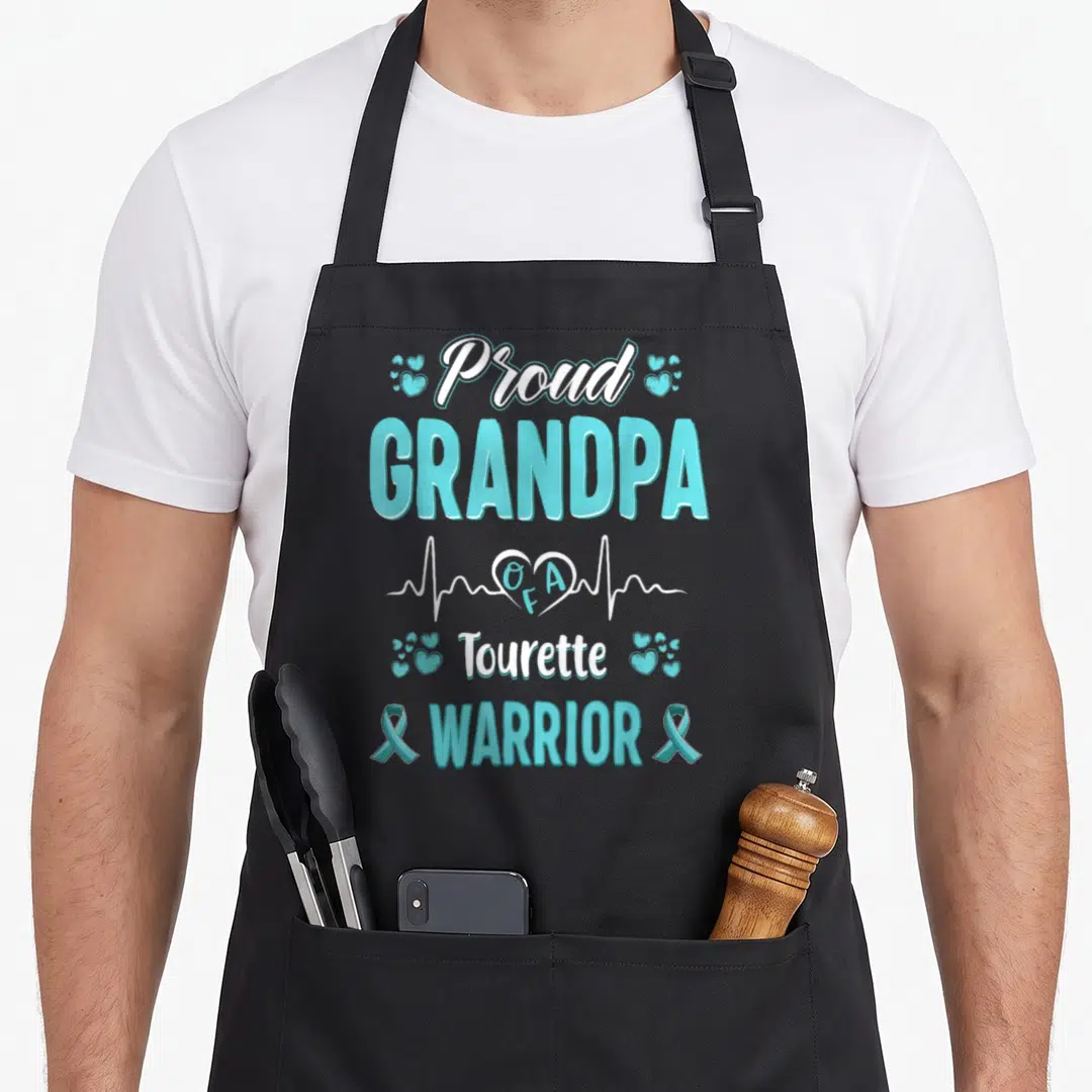 Tourette grandpa apron - Proud GRANDPA OFA Tourette WARRIOR text with blue ribbons and heartbeat line — shown on a black cotton canvas apron against a white background