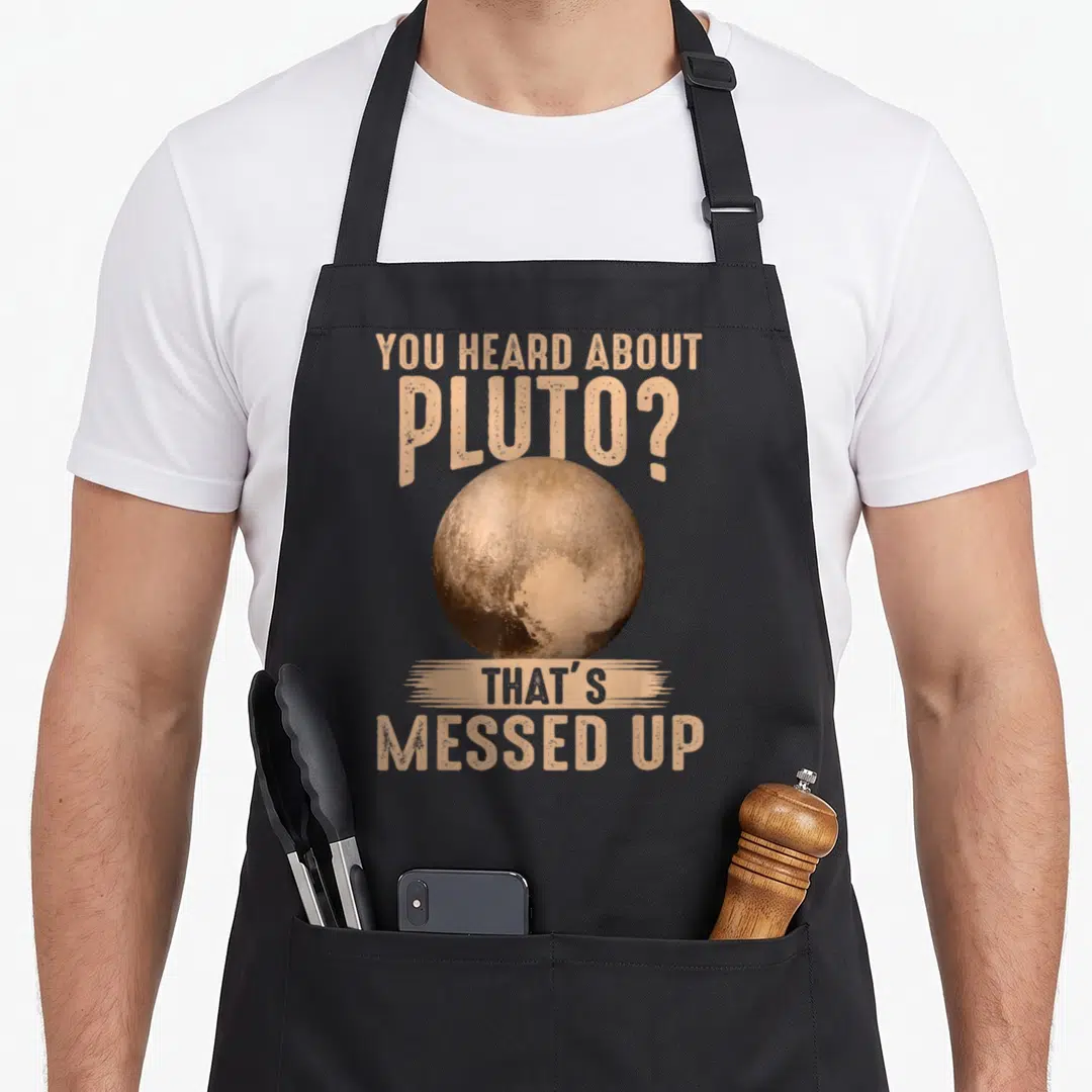 Heard novelty apron - Realistic brown planet surrounded by tan text reading You Heard About Pluto That's Messed Up — shown on a black cotton canvas apron against a white background