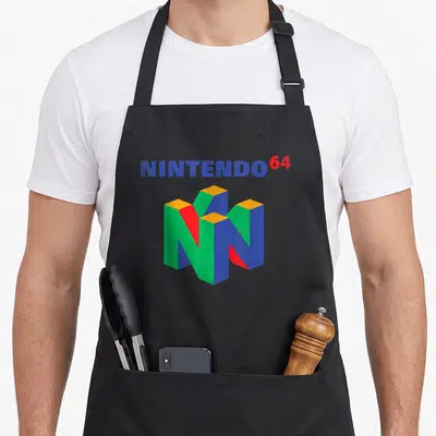 Fun apron - NINTENDO 64 text above a blue red green and yellow 3D N logo with distressed finish — shown on a black cotton canvas apron against a white background