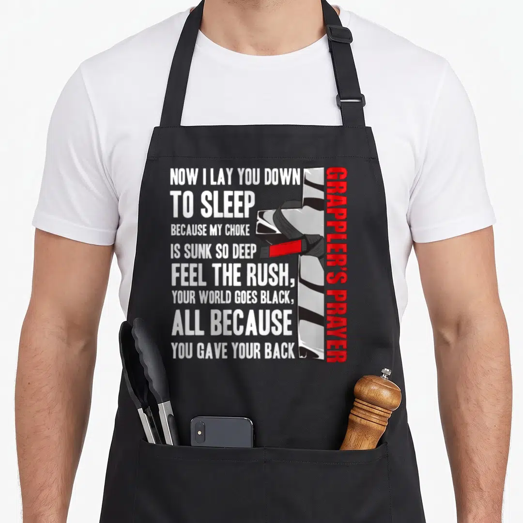 Jiu prayer apron - Grapplers Prayer text and martial arts belt illustration in black white and red — shown on a black cotton canvas apron against a white background