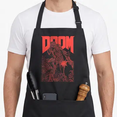 Doom video game apron - Red DOOM text with sketched Slayer and demons extending below in distressed style — shown on a black cotton canvas apron against a white background