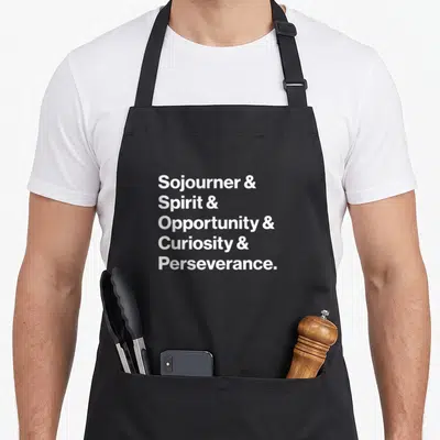 Opportunity nasa apron - White stacked text listing Sojourner Spirit Opportunity Curiosity Perseverance on black fabric — shown on a black cotton canvas apron against a white background