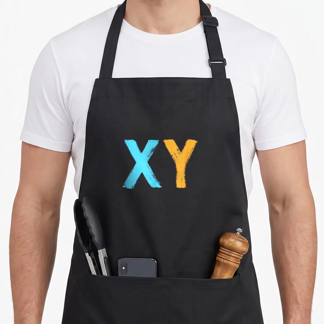 Dna chromosomes apron - XY letters in light blue and orange brushstroke font on gray background — shown on a black cotton canvas apron against a white background