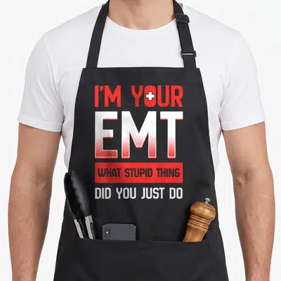 Technician emt apron - Red and white text I'M YOUR EMT with cross in O and red block reading WHAT STUPID THING — shown on a black cotton canvas apron against a white background